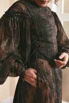 Black two-tone dress made of plain woven silk and lace, with long puffy sleeves and a backless style, ideal for fashion-forward women